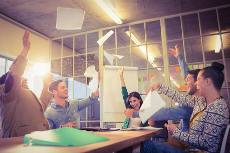 Group of business people celebrating by throwing their business papers in the air 