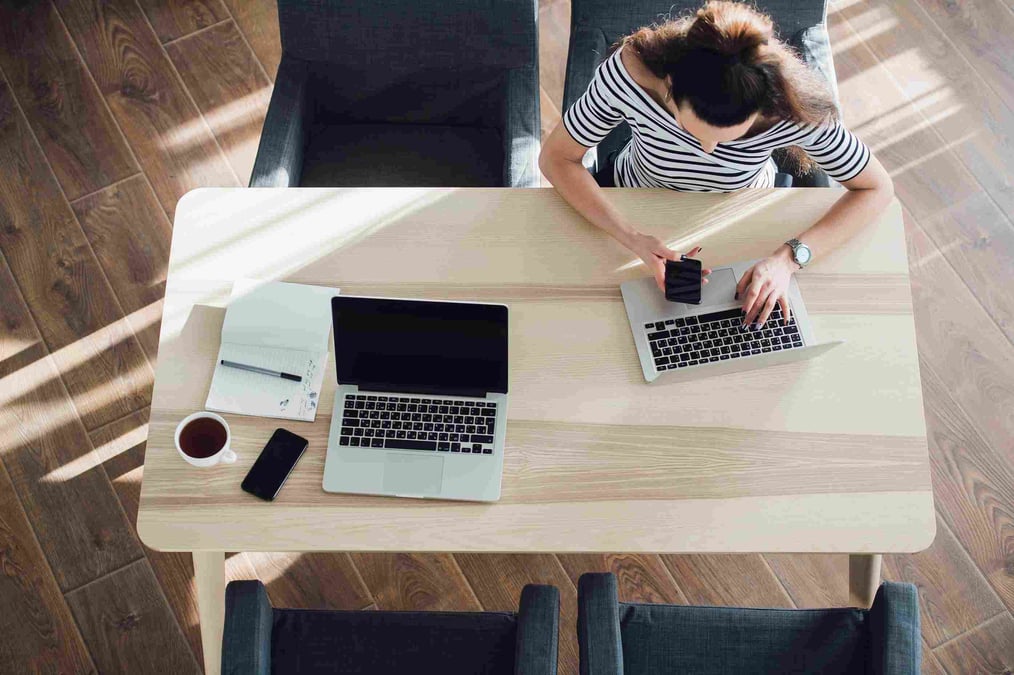 top-view-of-young-woman-sitting-at-desk-and-RM5KBN4 