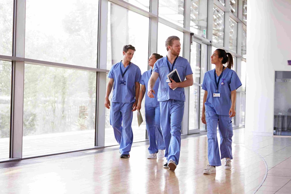 Male and female healthcare workers walk together 